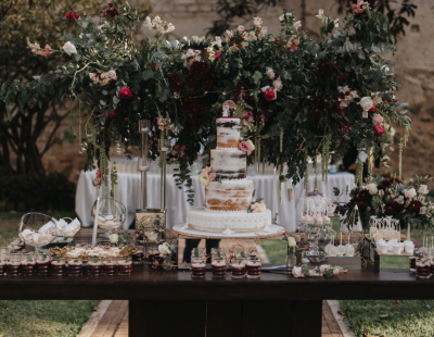 Photo from event. Flowers and cake arranged on a table