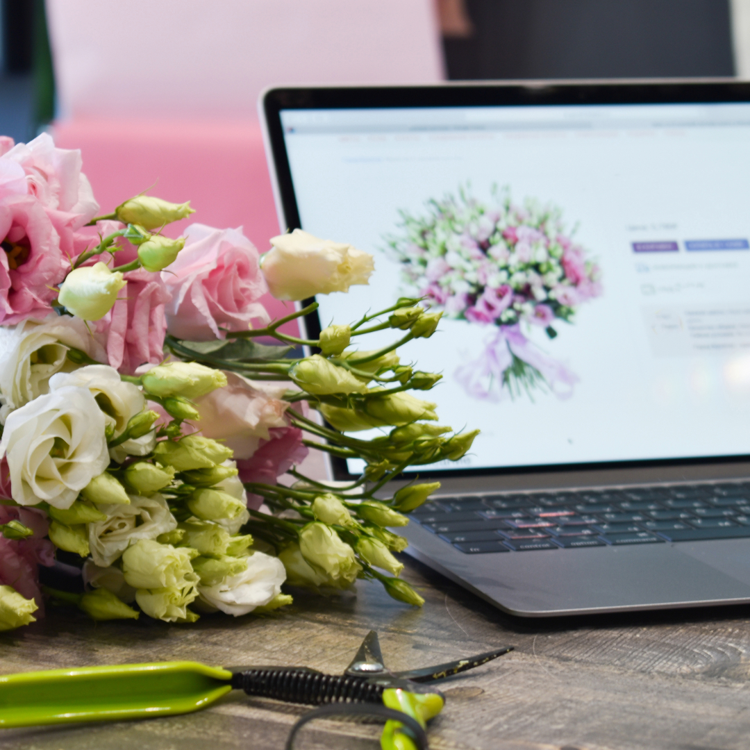 Picture showing flowers and computer in the background showing online flower shop